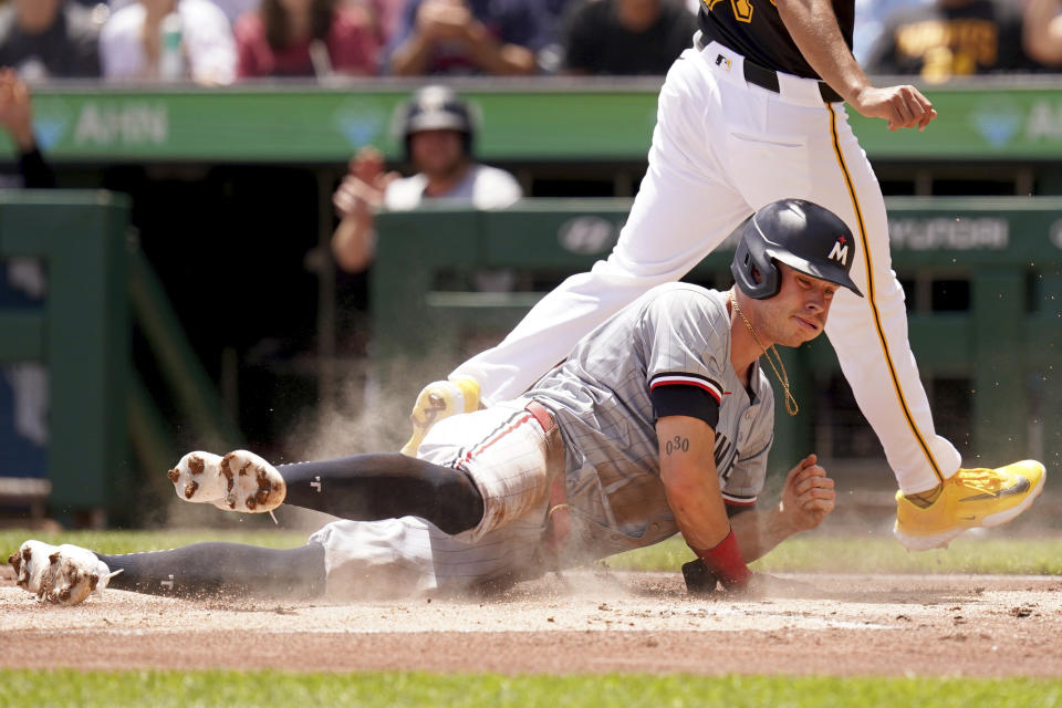 Minnesota Twins' Max Kepler, bottom, scores on a passed ball by Pittsburgh Pirates catcher Henry Davis (not shown) during the first inning of a baseball game against the Minnesota Twins, Sunday, June 9, 2024, in Pittsburgh. (AP Photo/Matt Freed)