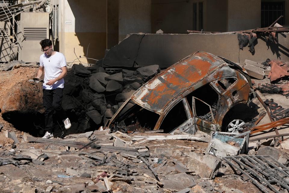 A man walks on rubble at the site of an Israeli airstrike in Beirut's southern suburbs (AP)