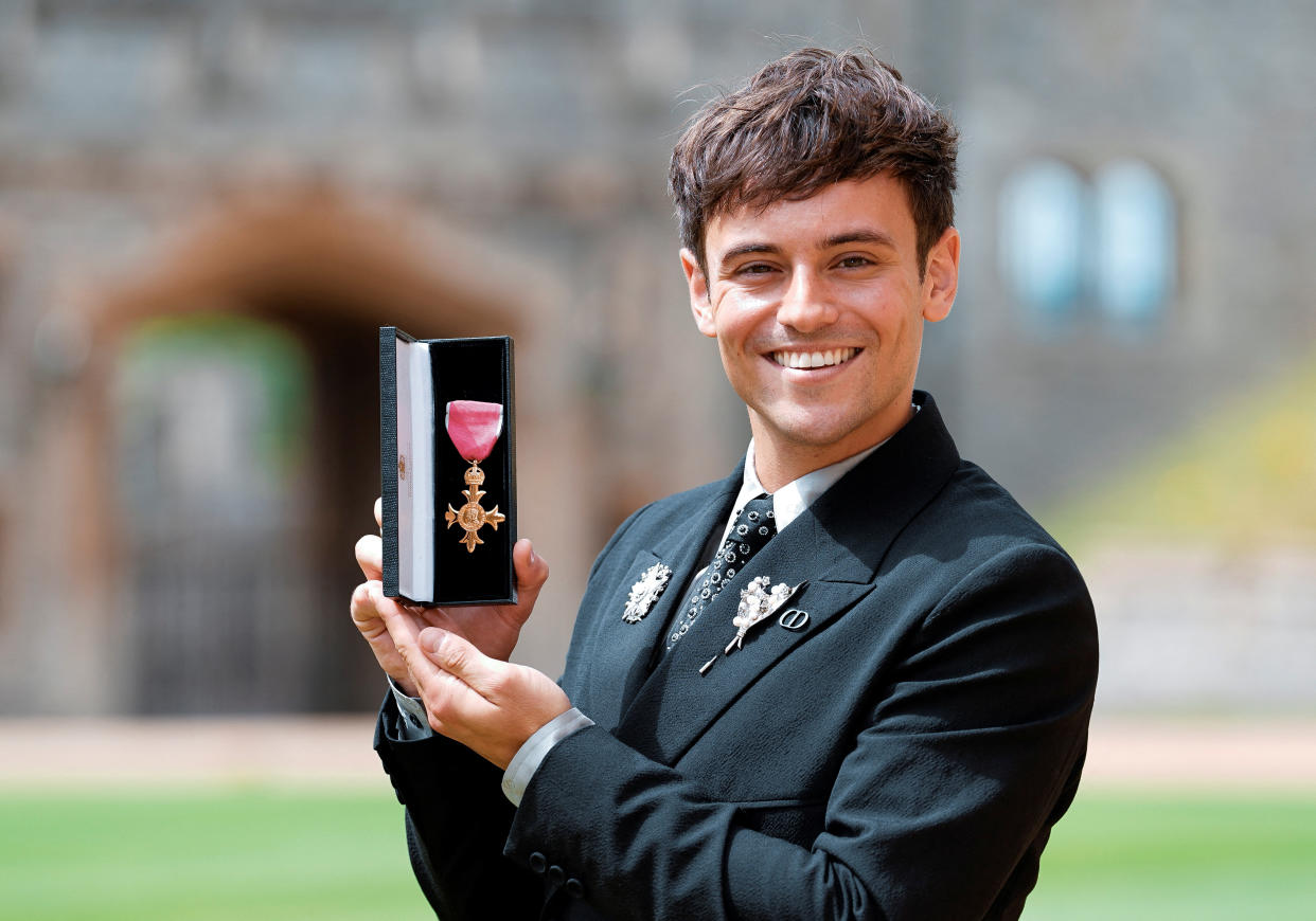 Tom Daley poses with his OBE (Officer of the Order of the British Empire) for services to diving, as well as in recognition of his charity work and his support of LGBTQ+ rights following an investiture ceremony at Windsor Castle, Britain July 12, 2022. Andrew Matthews/Pool via REUTERS