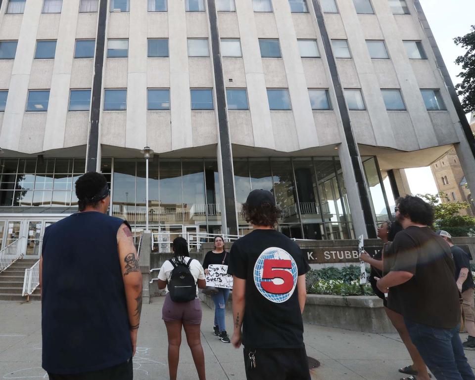 Cristhy Sotres, center, of Akron leads a chant during a protest of the APD shooting of Jayland Walker in front of the Akron Police Department at the Harold K. Stubbs Justice Center Friday afternoon in downtown Akron.