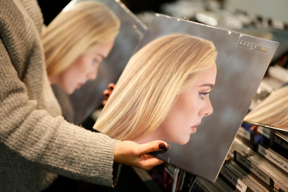 A member of staff sorts copies of the new album from British singer-songwriter Adele, 