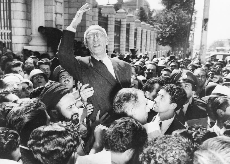 El primer ministro Mohammad Mossadegh es llevado en hombros por una multitud en la Plaza Majlis, frente al Parlamento, después de reiterar sus posturas sobre la nacionalización del petróleo a sus simpatizantes, el 27 de septiembre de 1951, en Teherán. (AP Foto, archivo)