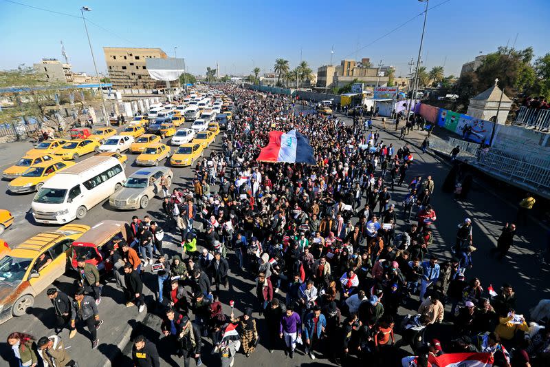 University students carry an Iraqi flag, during ongoing anti-government protests in Baghdad