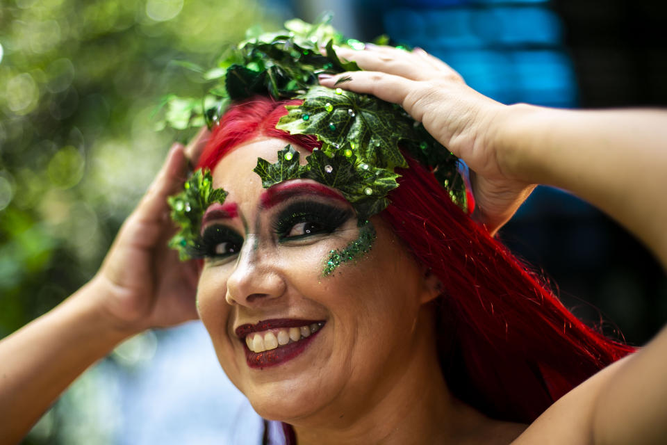 A member of the "Desliga da Justica" street band get dressed in her costume in Rio de Janeiro, Brazil, Sunday, Feb. 14, 2021. The group's performance was broadcast live on social media for those who were unable to participate in the carnival due to COVID restrictions after the city's government officially suspended Carnival and banned street parades or clandestine parties. (AP Photo/Bruna Prado)