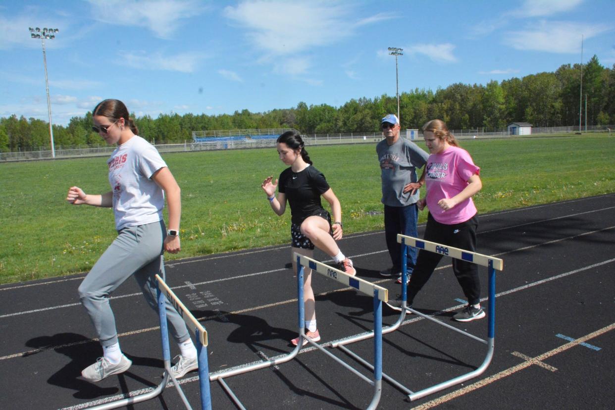 A trio of Sault High hurdlers step through some drills while coach Tony McLain, background, looks on at the Sault track this past week. Hurdlers, from left to right, include UP qualifiers Claire Erickson, Brianna Jones and Annabelle Fazzari.