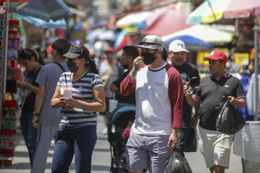 Los Angeles, CA - July 14: Sustained jumps in cases and hospitalizations fueled by the hyper-infectious BA.5 subvariant pushed Los Angeles County into the high COVID-19 community level Thursday, a shift that could trigger a new public indoor mask mandate by the end of this month unless conditions improve. Shoppers in mask and without masks in a very congested market Santee Alley on Thursday, July 14, 2022 in Los Angeles, CA. (Irfan Khan / Los Angeles Times)