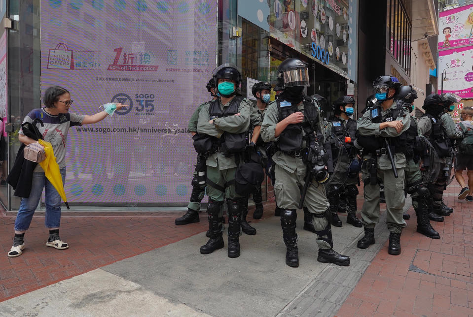 Image: Riot police standing guard as a woman tries to cross the street in the Central district of Hong Kong (Vincent Yu / AP)