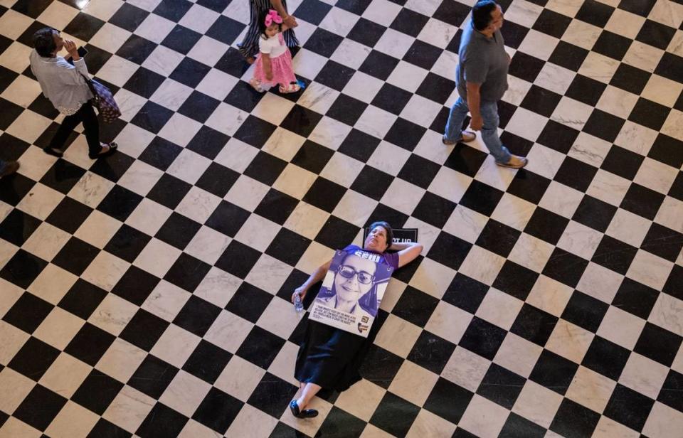 Francesca Wander, of Sacramento who works for the California State Department of Housing lays on the floor in the rotunda at the Capitol in protest Thursday during the SEIU Local 1000 silent march to draw attention to their fight for higher pay.