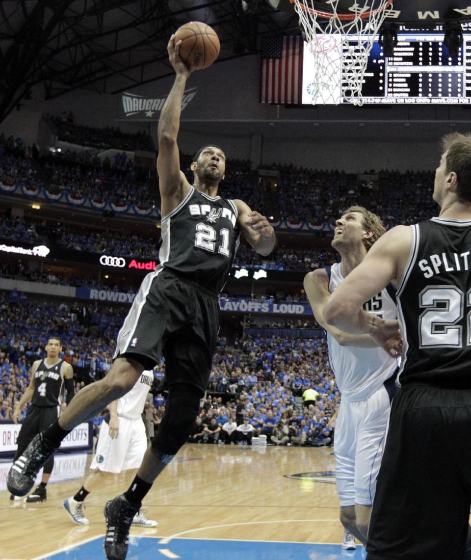 San Antonio Spurs' Tim Duncan (21) goes up for a shot over Dallas Mavericks' Dirk Nowitzki (41) as Tiago Splitter (22) watches in the first half of Game 4 of an NBA basketball first-round playoff series, Monday, April 28, 2014, in Dallas. (AP Photo/Tony Gutierrez)