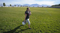 Sam Gordon walks across a field, Oct. 20, 2020, in Herriman, Utah. Gordon was the only girl in a tackle football league when she started playing the game at age 9. Now, Gordon hopes she can give girls a chance to play on female-only high school teams through a lawsuit. (AP Photo/Rick Bowmer)
