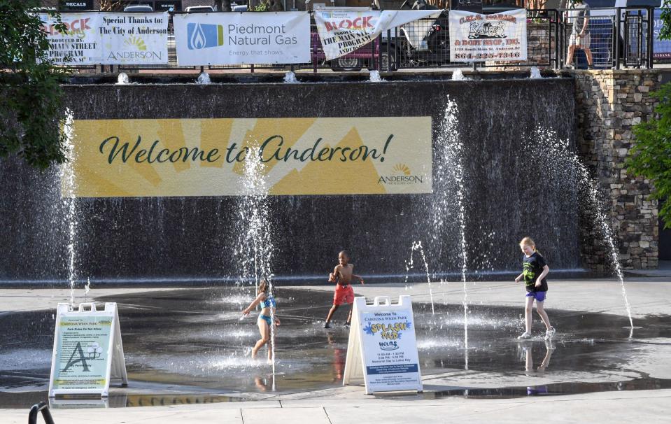 Children play in the splash pad at Carolina Wren Park with the temperature at 85-degrees in the early evening, while Piedmont Natural Gas Block Party moved under the shelter of the Wren Pavilion to be safe from forecast of possible rain in downtown Anderson, S.C. May 23.