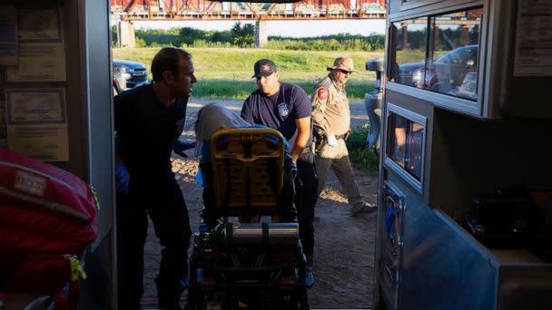 PHOTO: Firefighter EMT William Dorsey and firefighter EMT Rodrigo Pineda treat a migrant woman suffering from heat exhaustion in the border community of Eagle Pass, Texas, June 26, 2023. (Kaylee Greenlee Beal/Reuters)