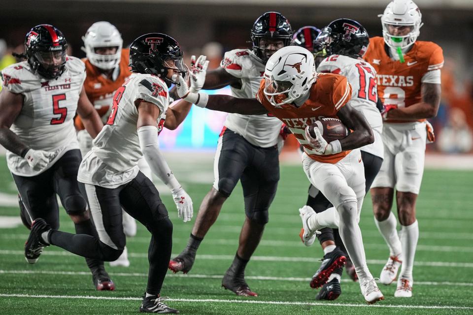 Texas Longhorns running back Quintrevion Wisner (26) runs down the field as he evades Texas Tech defensive back Jordan Sanford (28) during the game against Texas Tech at Darrell K Royal Texas Memorial Stadium on Friday, Nov. 24, 2023.