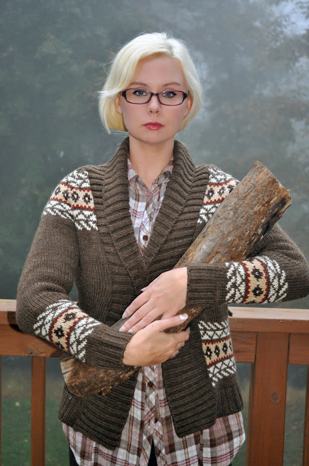 girl in a sweater holding a log