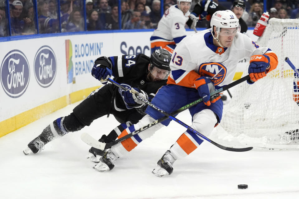 New York Islanders center Mathew Barzal (13) carries the puck ahead of Tampa Bay Lightning center Tyler Motte (64) during the second period of an NHL hockey game Saturday, March 30, 2024, in Tampa, Fla. (AP Photo/Chris O'Meara)