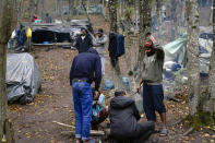 Migrants stand around improvised tents in a makeshift camp outside Velika Kladusa, Bosnia, Saturday, Sept. 26, 2020. Remote woods, abandoned run-down buildings and roadsides on the fringes of northwestern Bosnian towns are steadily filling with makeshift camps where migrants from the Middle East, Asia and North Africa are bracing for more misery as autumn's chill and rains set it. (AP Photo/Kemal Softic)