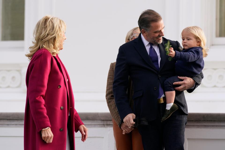 Little Beau Biden, right, son of Hunter Biden, holds a branch from the official 2021 White House Christmas tree given to him by first lady Jill Biden on Nov. 22, 2021.