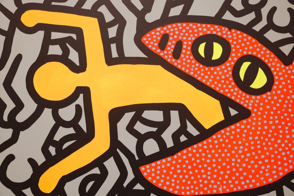 A detail of Keith Haring's painting of a creature eating a man.