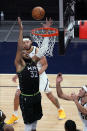 Minnesota Timberwolves' Karl-Anthony Towns (32) reaches for a rebound as Denver Nuggets' JaVale McGee, back, and Aaron Gordon watch during the first half of an NBA basketball game Thursday, May 13, 2021, in Minneapolis. (AP Photo/Jim Mone)