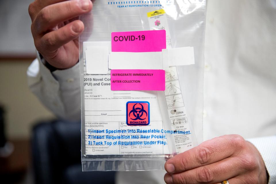 Bobby Rankin, practice manager of Physicians Express, holds up a COVID-19 test kit on Thursday, March 19, 2020. The practice received a limited amount of test kits and is making appointments to see patients in its office on Santa Fe Street, which opened on Thursday. Individuals who think they may have coronavirus will first be tested for the flu and strep throat, treated with anitiviruals for seven days and if they are still ill then they will receive a test, Rankin said.
