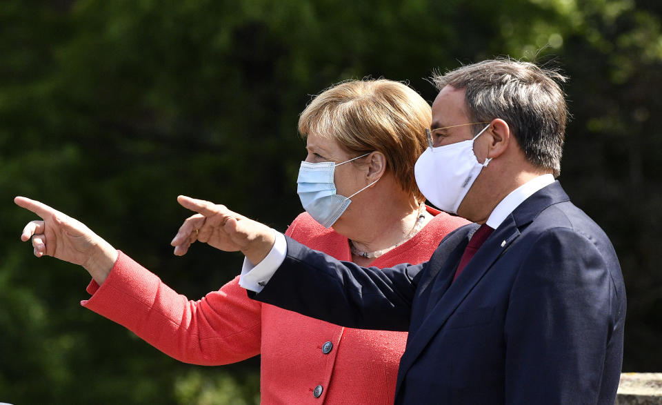 FILE - In this Tuesday Aug. 18, 2020 file photo, German chancellor Angela Merkel, left, and her successor as chairman of the German Christian Democratic Union, CDU, Armin Laschet, right, point during a meeting in Duesseldorf, Germany. Elections in two German states on Sunday pose a difficult test for Chancellor Angela Merkel's party, six months before a national vote that will determine who succeeds the country's longtime leader. (AP Photo/Martin Meissner, File)