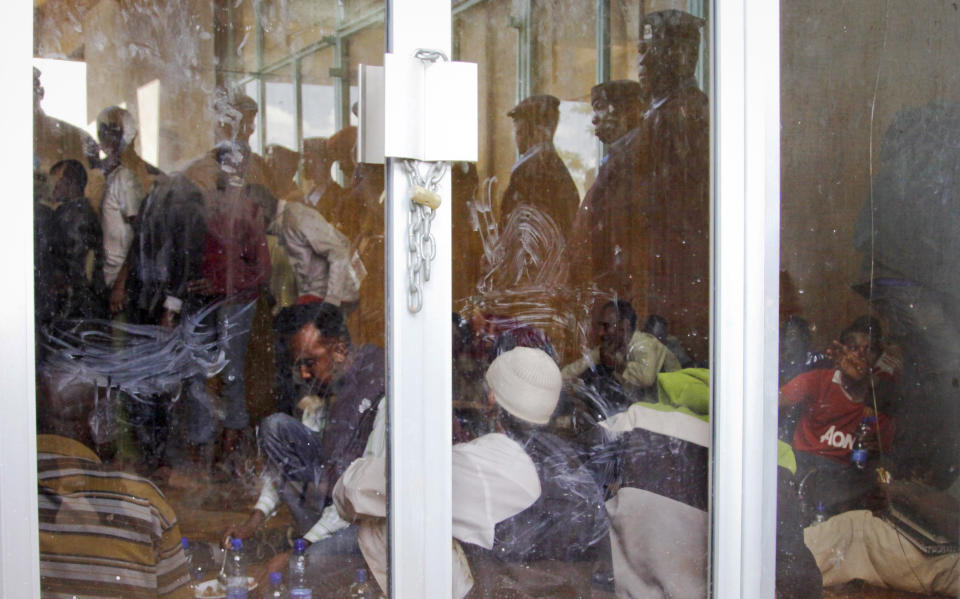 Detained Somali men sit inside a makeshift cell before being fingerprinted and screened at the Kasarani sports stadium, which has been converted into a detention facility to hold those arrested during recent security crackdowns, near Nairobi in Kenya Wednesday, April 9, 2014. Kenya's security minister said Wednesday that 82 Somali nationals have been deported in an ongoing security crackdown following recent terror attacks in Kenya's capital and the port city of Mombasa. (AP Photo/Khalil Senosi)