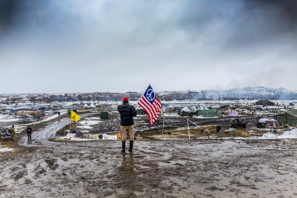 A defiant Dakota Access pipeline protester faces off against militarized police in 2017 as law enforcement raided their camp. (Photo: Pacific Press via Getty Images)