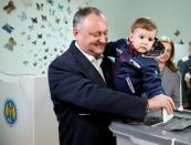 Moldova's Socialist Party presidential candidate Igor Dodon, accompanied by his wife Galina and son Nikolai, casts his vote at a polling station during a presidential election in Chisinau, Moldova, October 30, 2016. REUTERS/Gleb Garanich