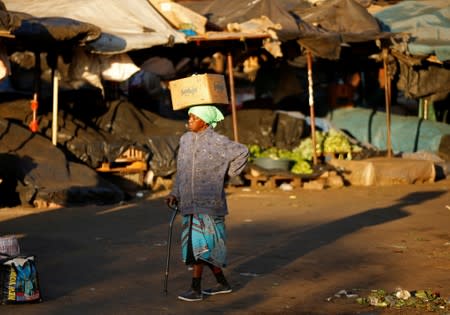 A woman walks at a vegetable market, after Zimbabwe police banned an anti-government demonstration, in Bulawayo