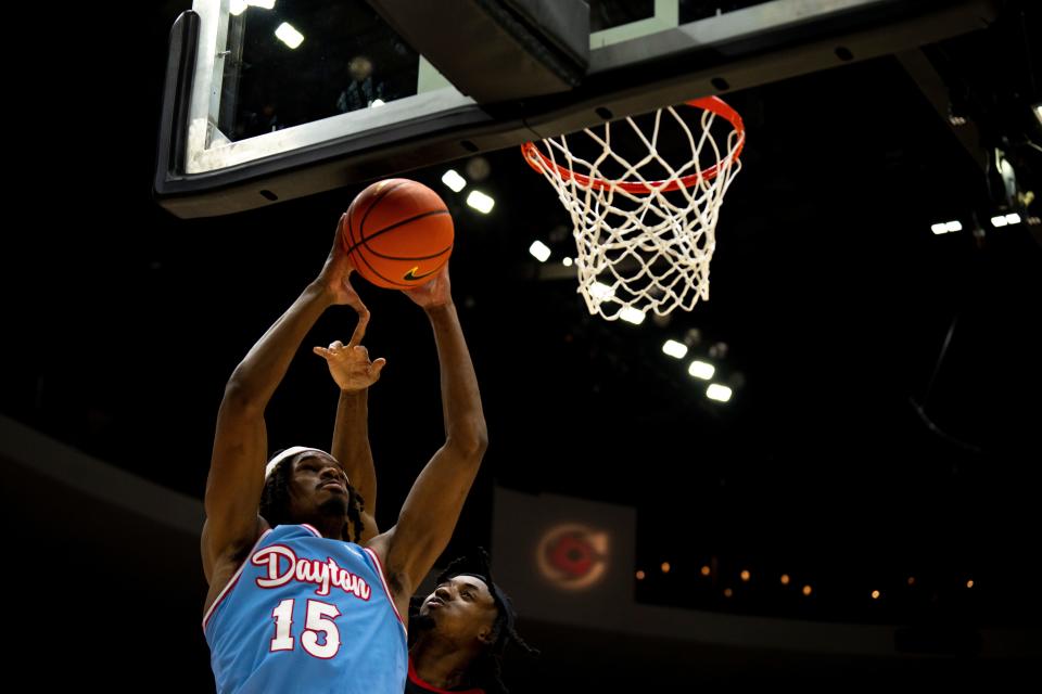 Dayton Flyers forward DaRon Holmes II (15) draws a foul from Cincinnati Bearcats guard Day Day Thomas (1) in the second half of the NCAA men's basketball game between the Dayton Flyers and Cincinnati Bearcats at Heritage Bank Center in Cincinnati on Saturday, Dec. 16, 2023.