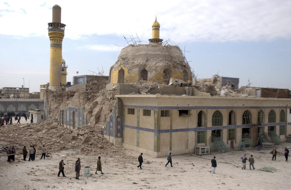 FILE - In this Feb. 22, 2006, file photo, Iraqis walk past the damaged Askariya shrine following an explosion in Samarra, north of Baghdad. (AP Photo/Hameed Rasheed, File)