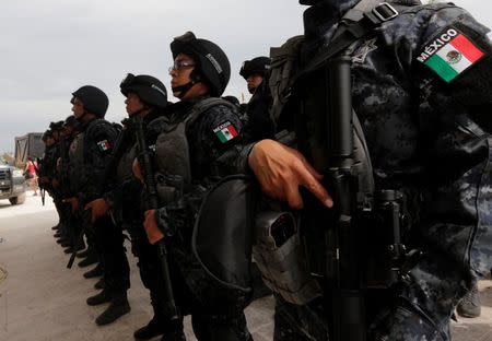 Federal police officers stand in formation as stranded tourists (not pictured) wait for a Mexican Army plane, outside the international airport in San Jose del Cabo after Hurricane Odile hit in Baja California, September 19, 2014. REUTERS/Henry Romero