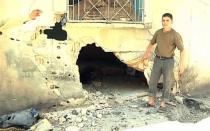 An image grab taken from a video released by the United Nations Supervision Mission in Syria (UNSMIS) shows a youth pointing out a shelled house to UN observer in the central flashpoint city of Homs