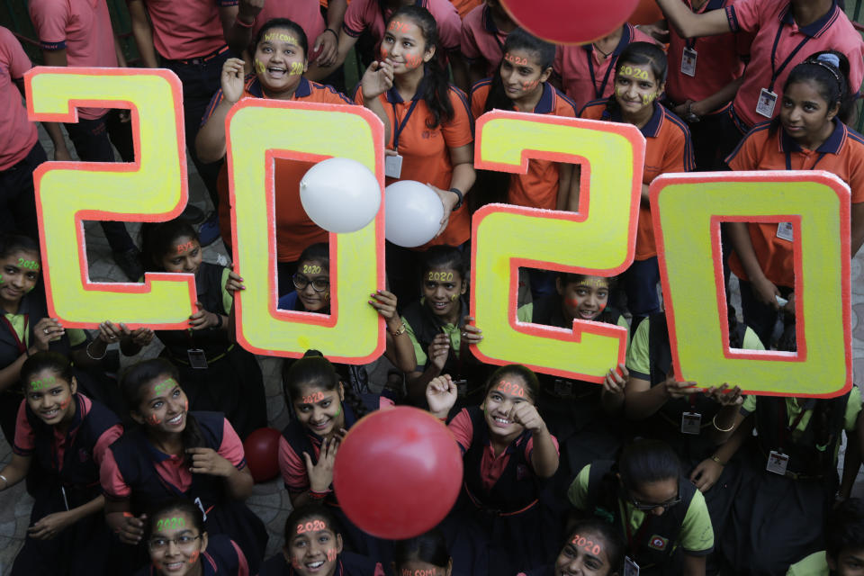 Unos niños posan para las cámaras durante un festejo por el Año Nuevo en Ahmadabad, India, el martes 31 de diciembre de 2019. (AP Foto/Ajit Solanki)