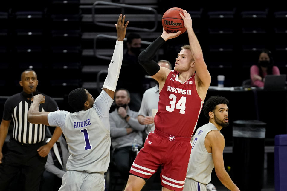 Wisconsin guard Brad Davison, front right, shoots as Northwestern guard Chase Audige guards during the first half of an NCAA college basketball game in Evanston, Ill., Saturday, Feb. 21, 2021. (AP Photo/Nam Y. Huh)