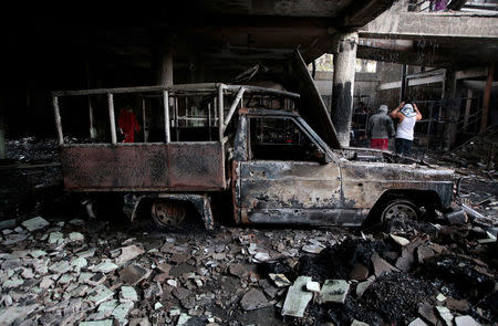 Men stand inside a burned house where, according to local media, six people died, during a protest against Nicaragua's President Daniel Ortega's in Managua, Nicaragua June 16, 2018. REUTERS/Oswaldo Rivas