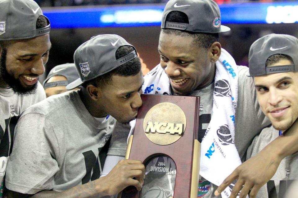 Patric Young, Will Yeguete and Scottie Wilbekin watch as Casey Prather kisses the South Regional Championship trophy after defeating Dayton 62-52 in the Elite Eight on Saturday, March 29, 2014 in Memphis, Tenn.