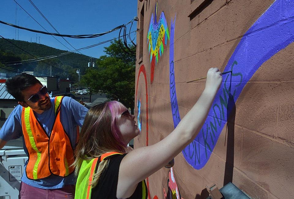 Hannah Glosenger works on a mural as Rockwell Museum Artist-in-Residence Brad Leiby looks on. The mural was the seventh sponsored by the Rockwell Museum around Corning. The museum and public art helped Corning earn nationwide recognition for "Best Small Town Cultural Scene."