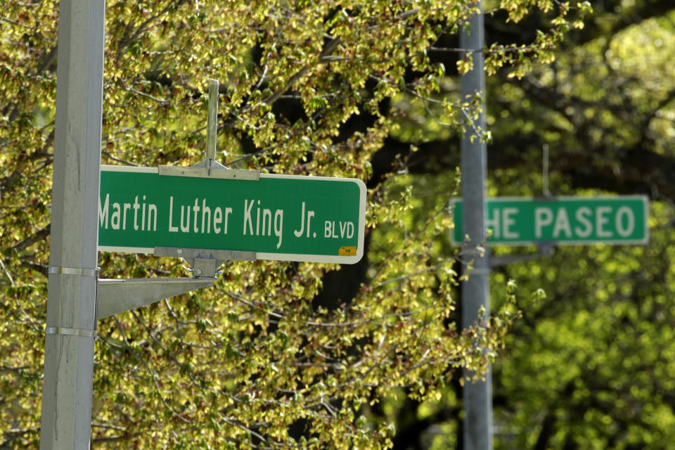 FILE - In this April, 20, 2019, file photo, a newly changed sign for Dr. Martin Luther King Jr. Boulevard stands in contrast to a yet-to-be changed sign for The Paseo, in Kansas City, Mo. More than 50 years after King was assassinated, the city's efforts to honor the civil rights leader has met opposition from citizens opposed to the renaming of The Paseo, one of the city's iconic boulevards. (AP Photo/Charlie Riedel, File)