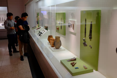 Visitors at Seoul's National Museum of Korea examine a display of artefacts from Gojoseon, the first unified Korean kingdom, said to have lasted from 2333 BCE to 108 BCE, in Seoul, South Korea October 7, 2018. Picture taken October 7, 2018. REUTERS/Josh Smith