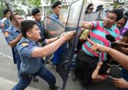 Members of Philippine women's group Gabriela are pushed back by police during a surprise rally near the gates of Malacanang palace in Manila on March 7, 2013 accusing President Benigno Aquino of mishandling the Sabah stand-off situation. Malaysia said clashes between intruding Filipino militants and its security forces in Sabah had left 60 people dead as of late Thursday