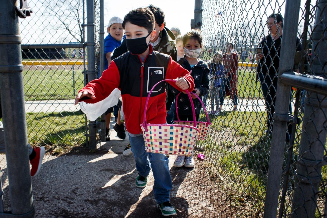 Payton Warner, 8, of Des Moines, leads a line of kids onto a ball field to pick up scattered Easter eggs at the Fort Des Moines Little League park on Saturday, April 3, 2021, in Des Moines, IA. Southside Cares hosted the Easter egg hunt after canceling last year due to the pandemic.