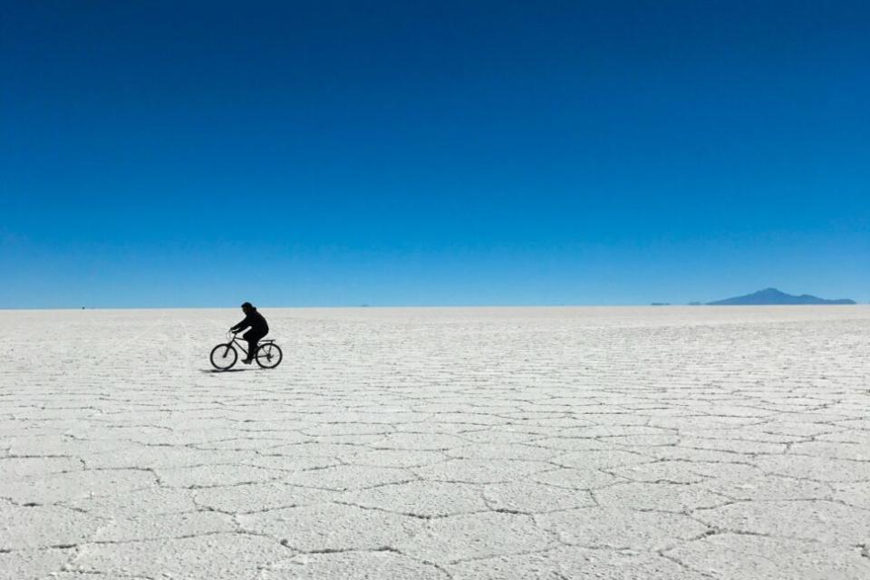 person riding bicycle across salt flat