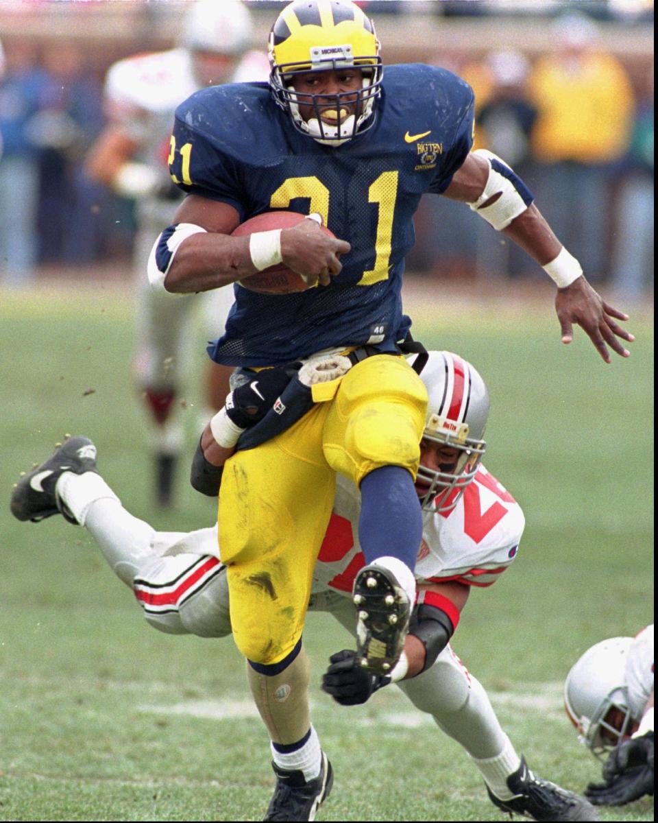 Michigan running back Tim Biakabutuka high-steps past an Ohio State defender to gain some of his career-high 313 rushing yards Nov. 24, 1995 in Ann Arbor.