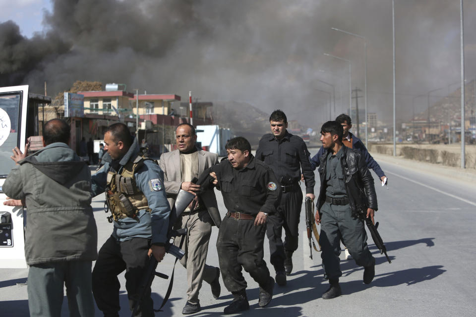 Afghan security forces help a comrade wounded in a suicide attack in Kabul, Afghanistan, Wednesday, March 1, 2017. A pair of suicide bombings, both claimed by the Taliban, struck the Afghan capital, an Afghan official said. (AP Photo/Rahmat Gul)