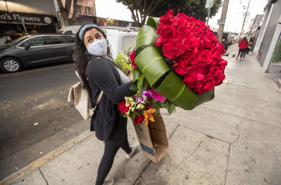 A woman walks with flowers