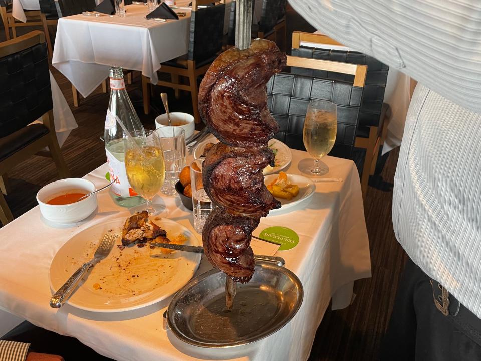 skewer of meat on a table at fogo de chao steak house