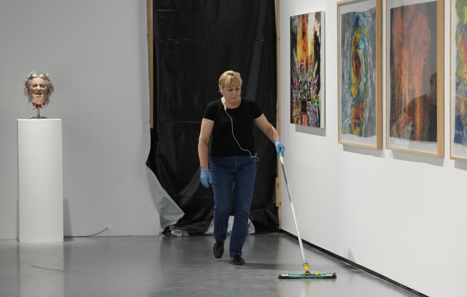 A worker cleans near an exhibit by Danish conceptual artist Kristian von Hornsleth at the Ujazdowski Castle Center for Contemporary Art in Warsaw, Poland, Wednesday Aug. 25, 2021. The exhibition which opens Friday at the Polish state museum features the works of provocative artists in what organizers describe as a celebration of free speech, and a challenge to political correctness and "cancel culture" on the political left. Some critics, however, accuse the organizers of the show titled "Political Art" of giving a platform to anti-Semitic, racist and Islamophobic messages. (AP Photo/Czarek Sokolowski)