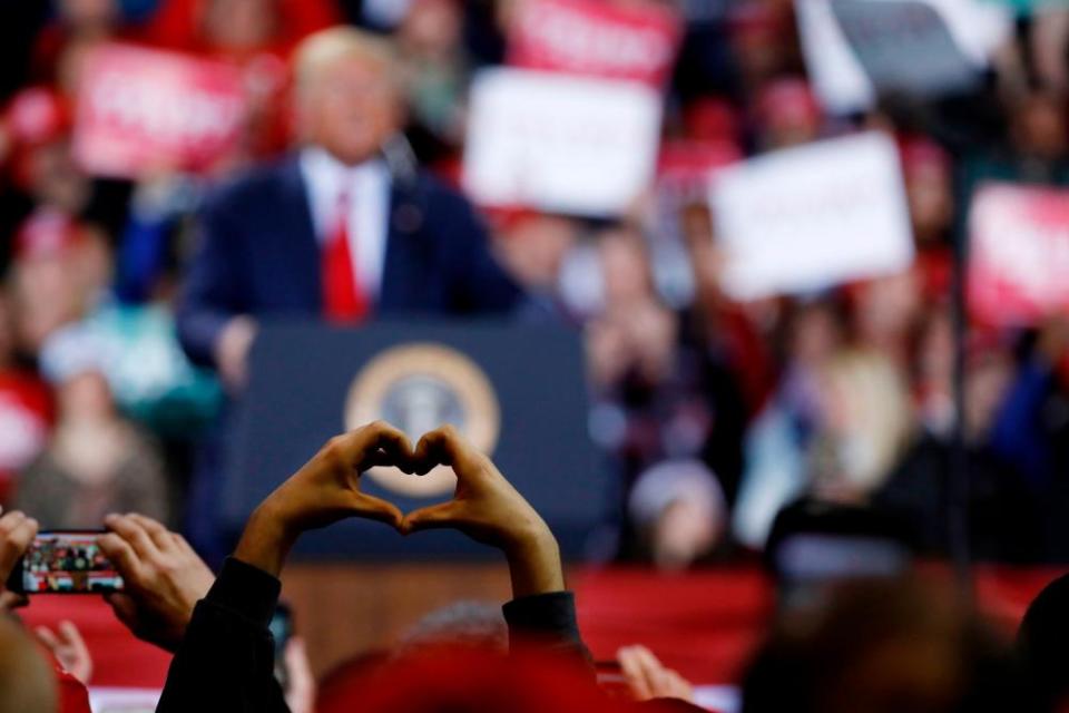 A supporter raises their hands in a heart gesture as Donald Trump speaks during a rally in Battle Creek, Michigan, on 18 December.