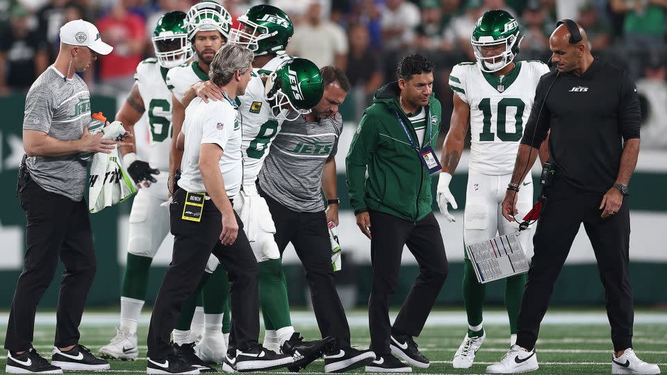 Rodgers is helped off the field by team trainers after suffering the Achilles injury during the first quarter of the Jets' game against the Buffalo Bills. - Elsa/Getty Images